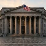 Federal courthouse exterior with steps, classical columns, and American flag at golden hour